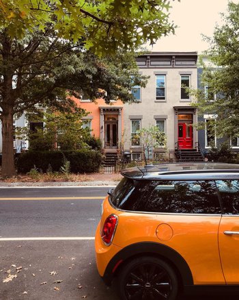 @feisty_foreigner - orange car with row houses in the background