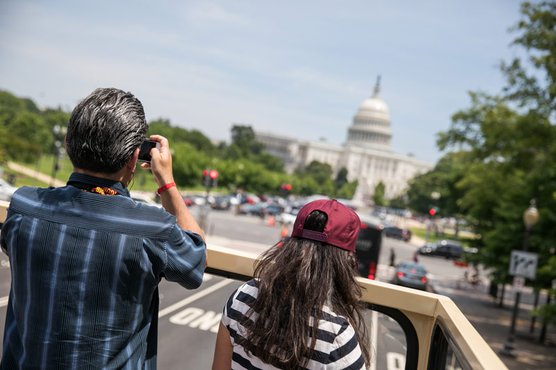 Visitors on a Big Bus sightseeing tour taking photos of the U.S. Capitol - Open-top bus tours in Washington, DC